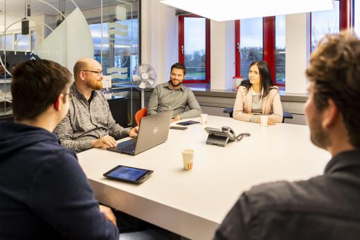 Alewijnse  colleagues meeting around work table